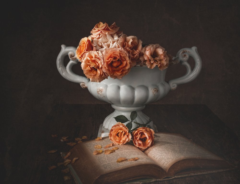 Melankoliska rosor och en gammal bok av Margareth Perfoncio