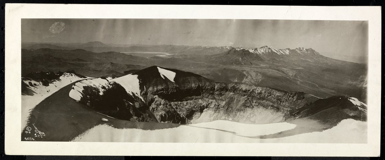 Panoramavy ovanifrån över en rad snöklädda berg och vad som verkar vara kanten av en vulkan, troligen på eller nära Panamakanalen, 1913 (silvergelatintryck) av Byron Company