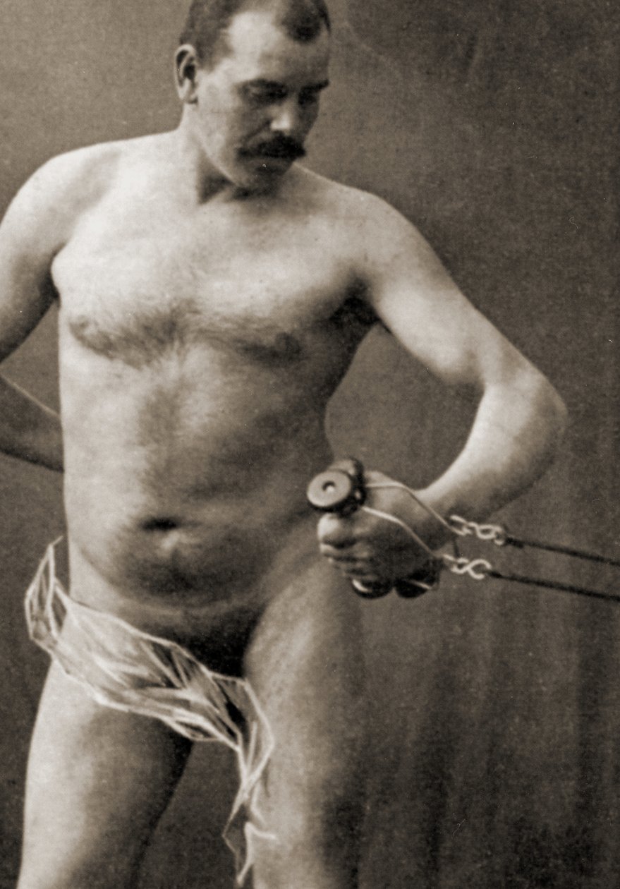 Naken hane som håller i handtaget på en kabelmaskin, ca 1910 (sepiafoto) av Unknown