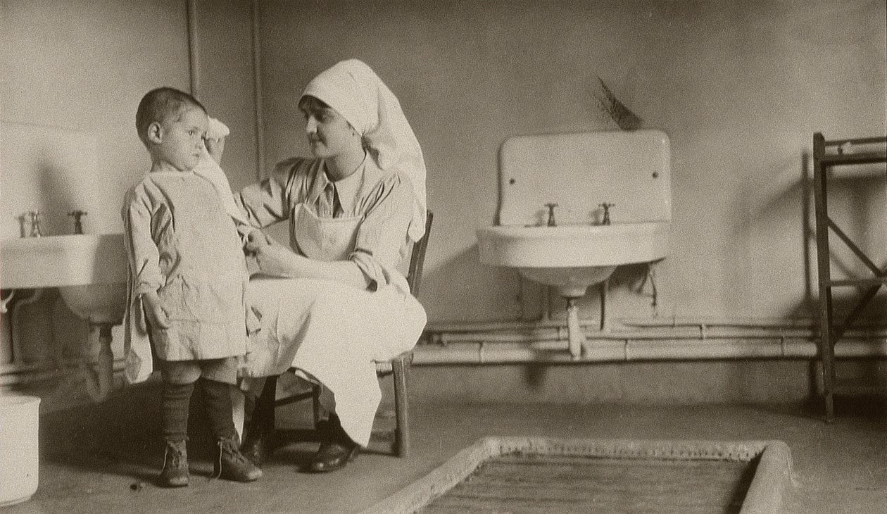 Nurse tending a sick child at Passay and Saint-Quentin colonies for refugees and orphans, 1919  av American Photographer