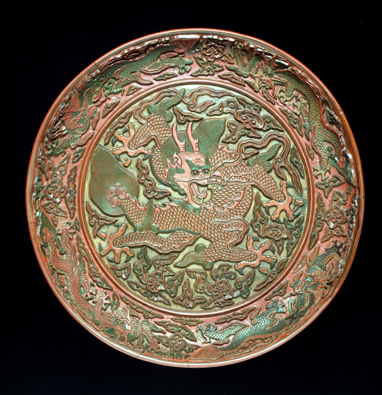 Cirkulärt fat dekorerat med nio drakar, Mingdynastin 1403-1644, Jianjing-perioden 1522-66 (ristad lack) av Chinese School