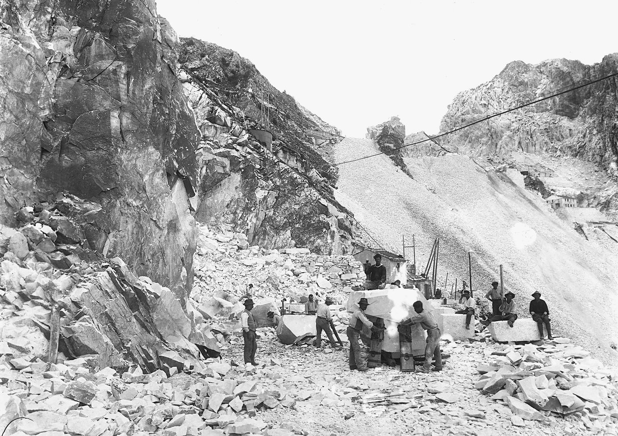 Grävare i arbete vid ett marmorbrott i Apuanska Alperna, Toscana. Några av dem sitter på marmorblock som redan är avjämnade. (svart/vitt foto) av A. Corsini