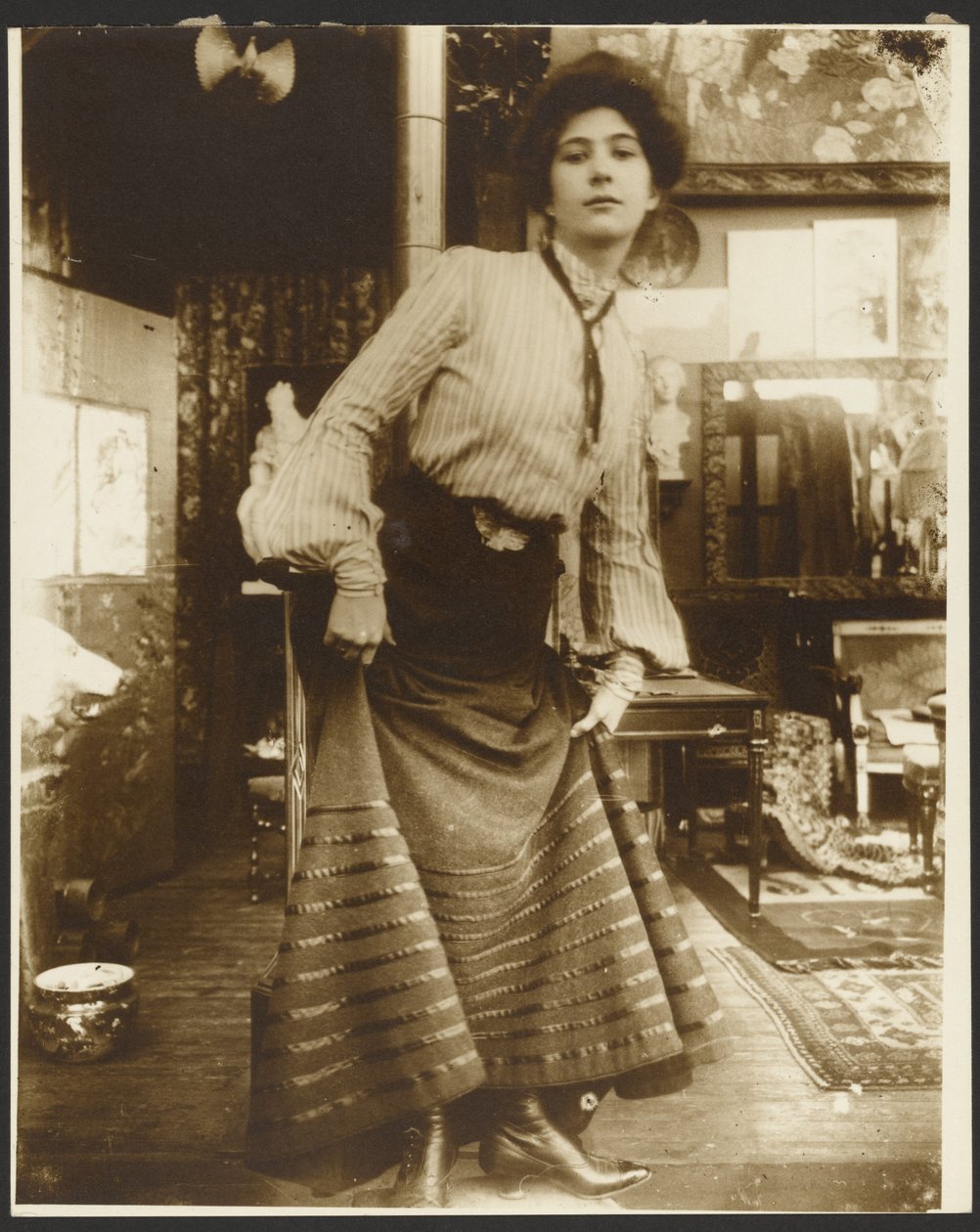 [Kvinnlig modell i randig blus och långklänning, Paris] av Alphonse Maria Mucha