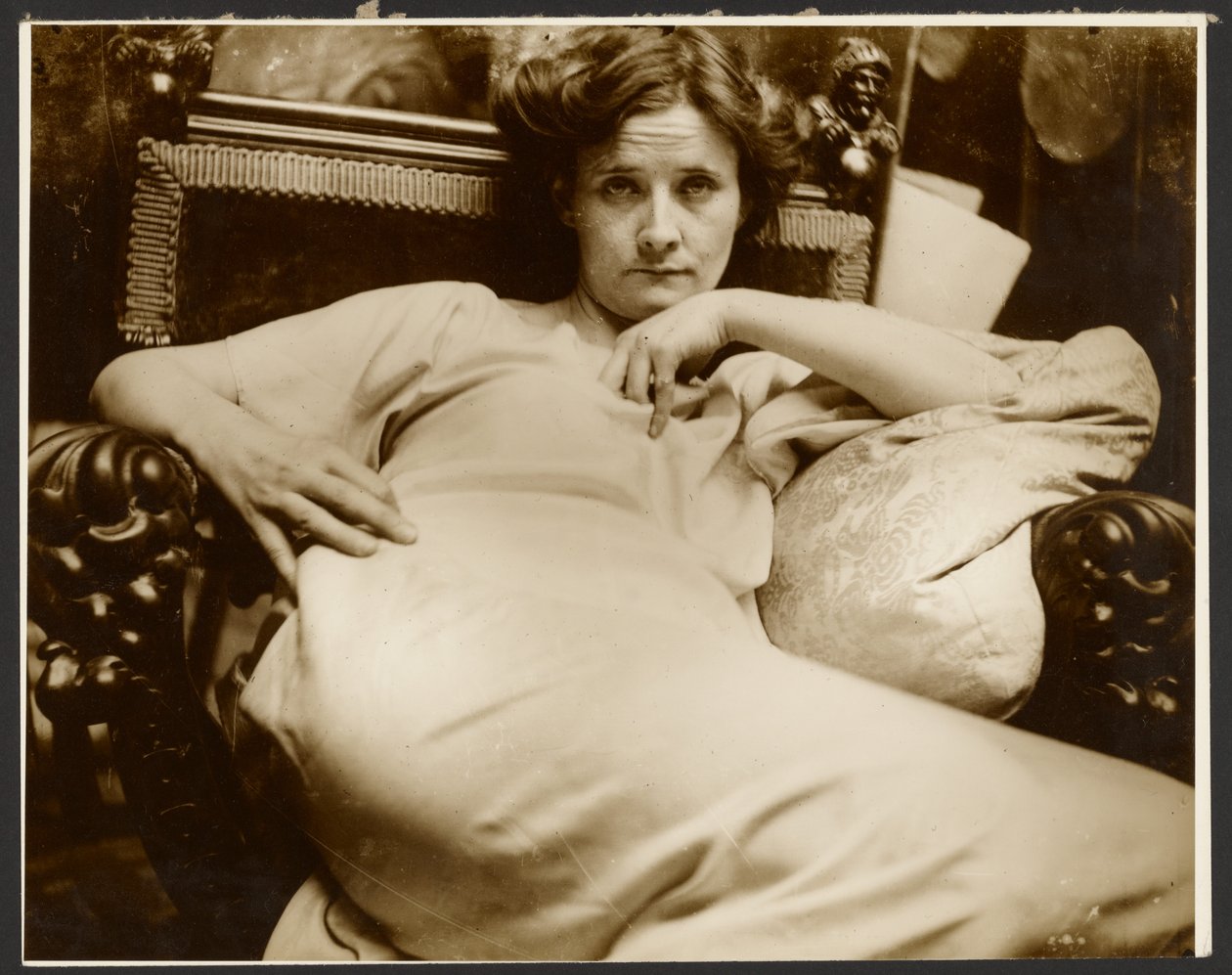 [Kvinnlig modell i en fåtölj, Paris] av Alphonse Maria Mucha