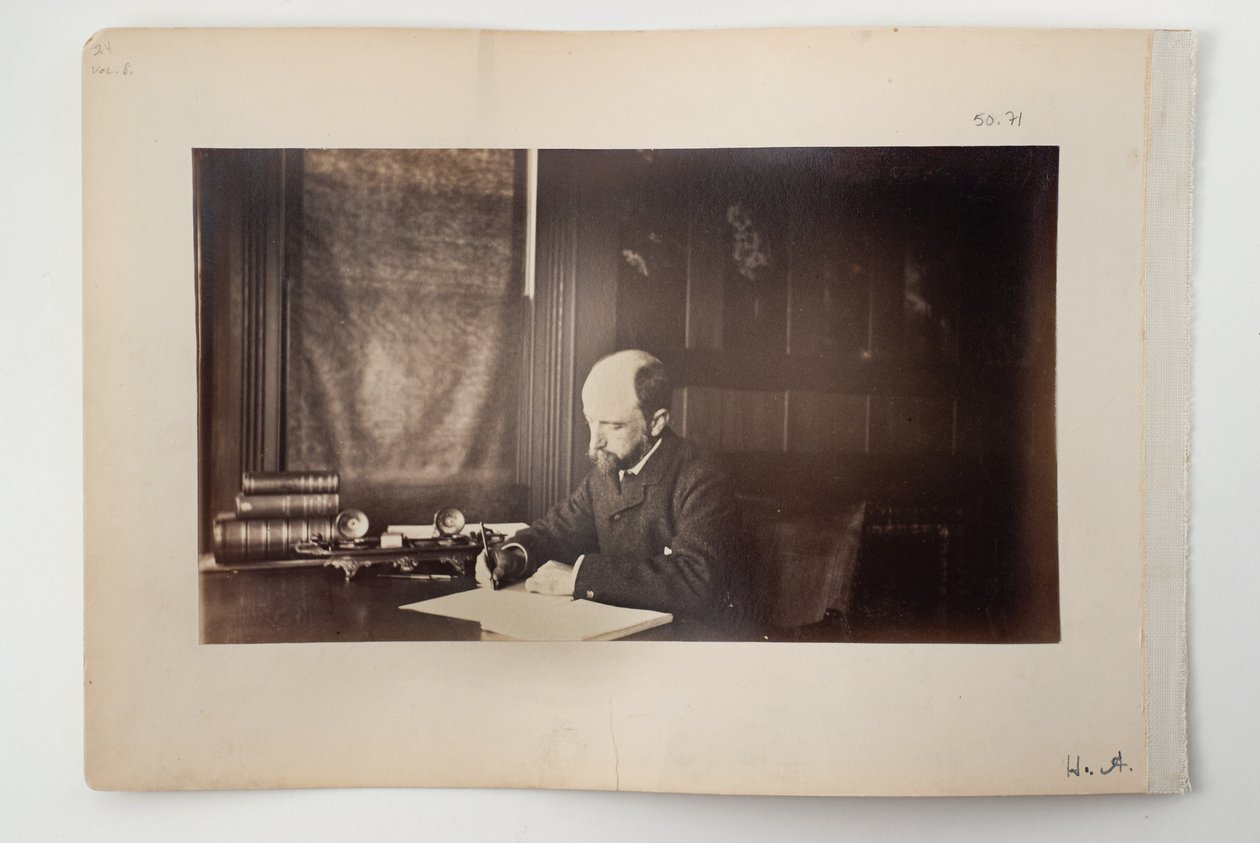 Henry Adams sittande vid ett skrivbord, 1883 av American Photographer