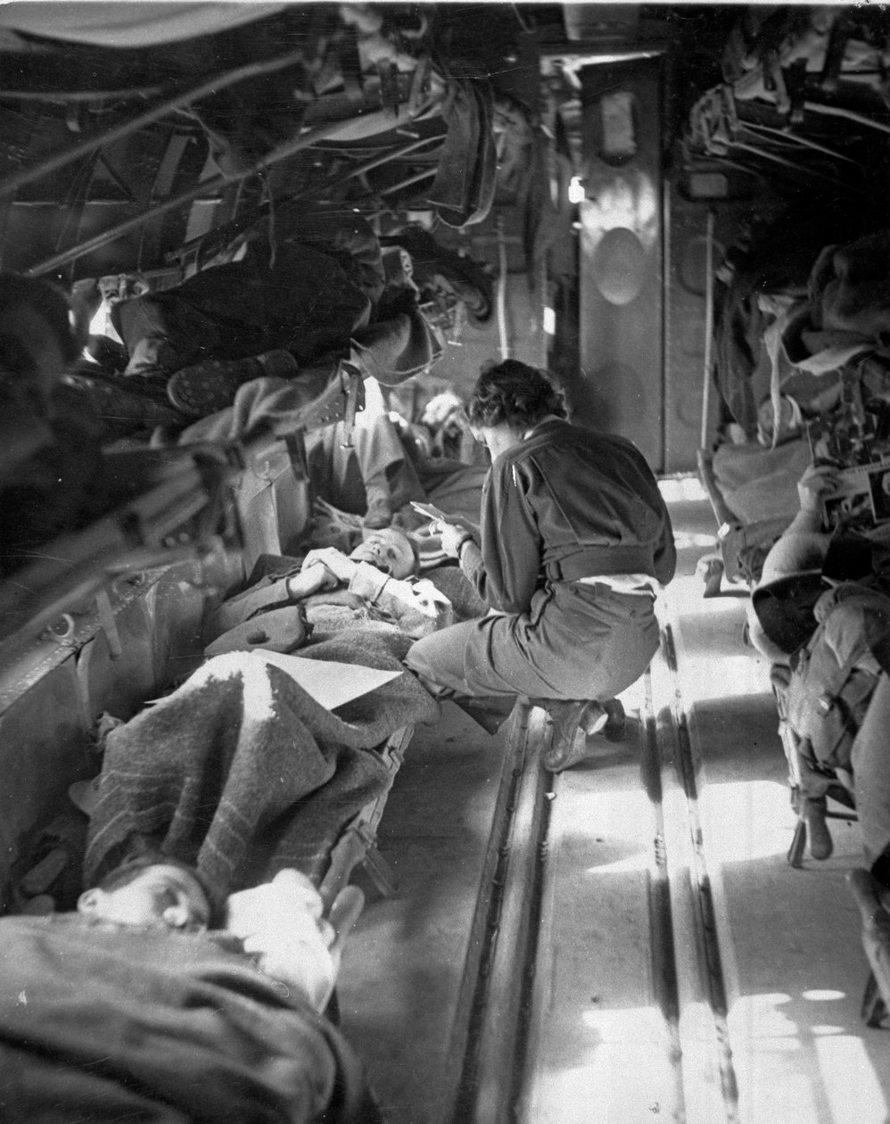 Miss Mary Smith från South Carolina behandlade patienter under flygningen till Nordafrika, ca 1943-45, från en samling av 650 fotografier sammanställda av Commando Association av American Photographer