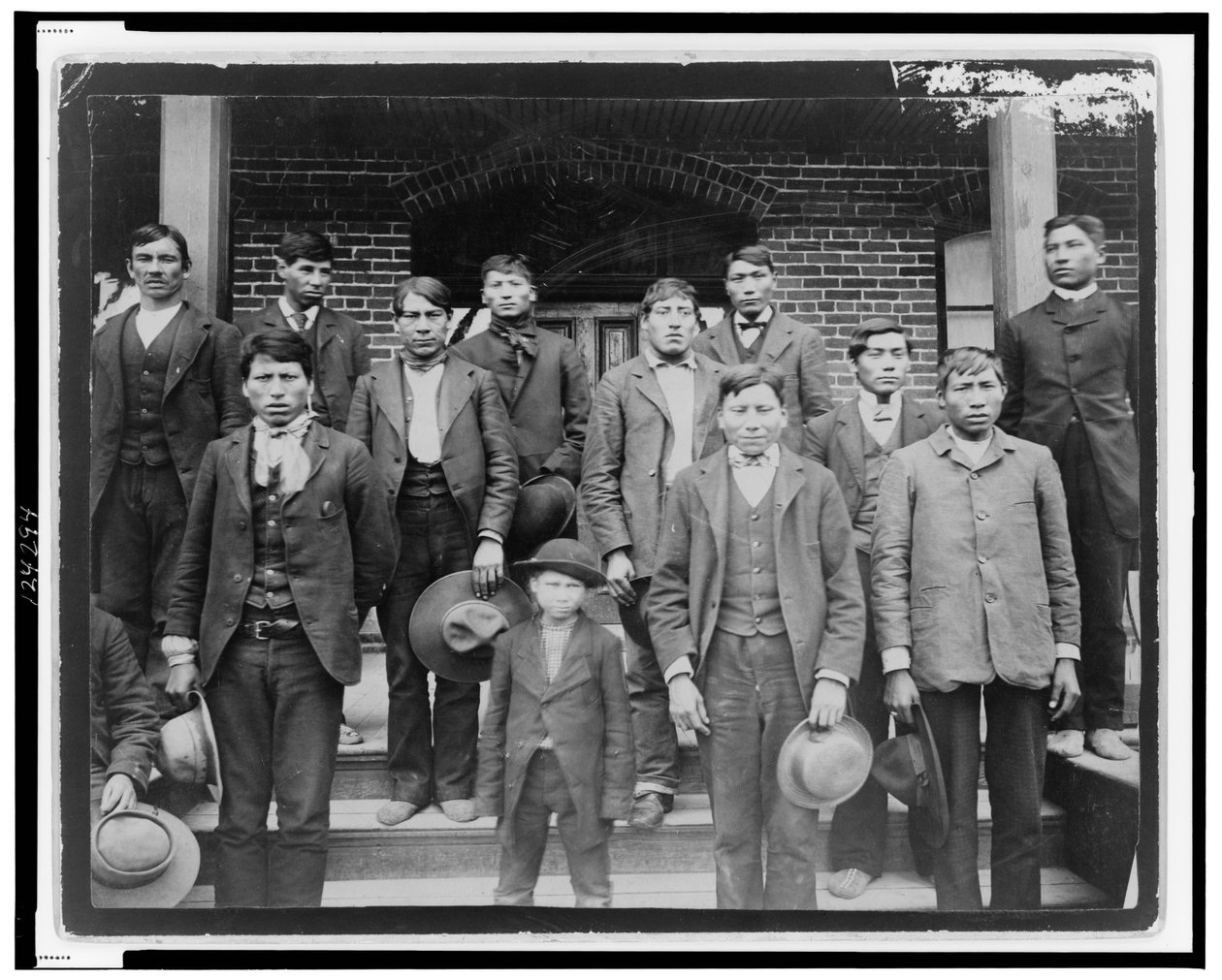 Indianska män och en pojke poserade utanför Carlisle Indian School, Pennsylvania, ca 1890 (s/v foto) av American Photographer