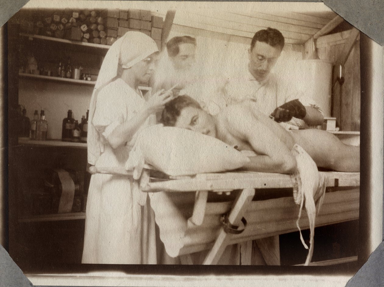 Första världskriget 1914-1918: läkare och sjuksköterska som behandlar en soldats sår i omklädningsrummet, lägret i Couville i Engelska kanalen, Nedre Normandie (Negre Normandie), Frankrike. Anonymt fotografi juli 1917. Privat samling, Stella. av Anonymous Anonymous