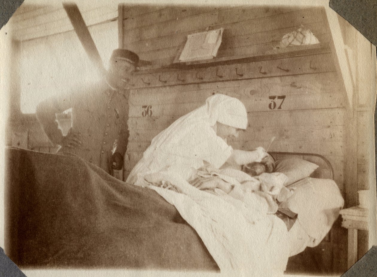 Första världskriget 1914-1918: sjuksköterska i blus rakar en soldat (franska krigssår ligger i en säng), i Couville, Manche, Basse-Normandie (Lagre Normandie), Frankrike. Anonymt fotografi juli 1917. Privat samling, Stella. av Anonymous Anonymous