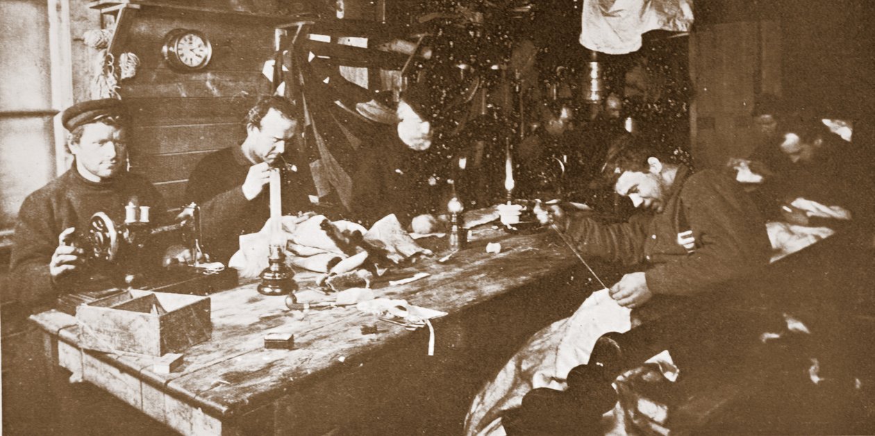 I Hut under midvintern ägnade sig männen åt att sy pälsar till kläder som skulle användas under vårens pulka, pub. London 1907 (s/v foto) av Anthony Fiala