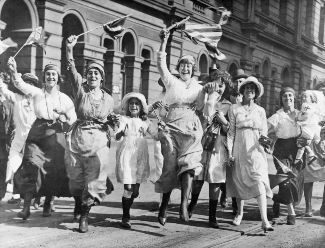 En grupp kvinnor och barn som jublar på en gata i Sydney vid undertecknandet av vapenstilleståndet den 11 november 1918 av Australian Photographer