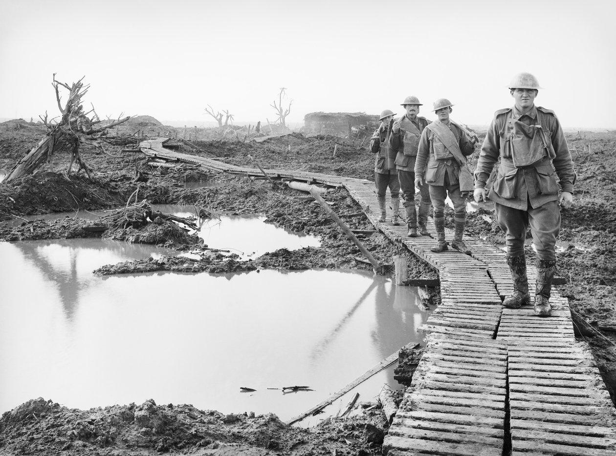 Fyra australiska soldater som går längs ankbrädesspåret vid Tokio, nära Zonnebeke, i Ypres-sektorn, över en del av landet som fångats av australierna i striderna under det tredje slaget av Australian Photographer