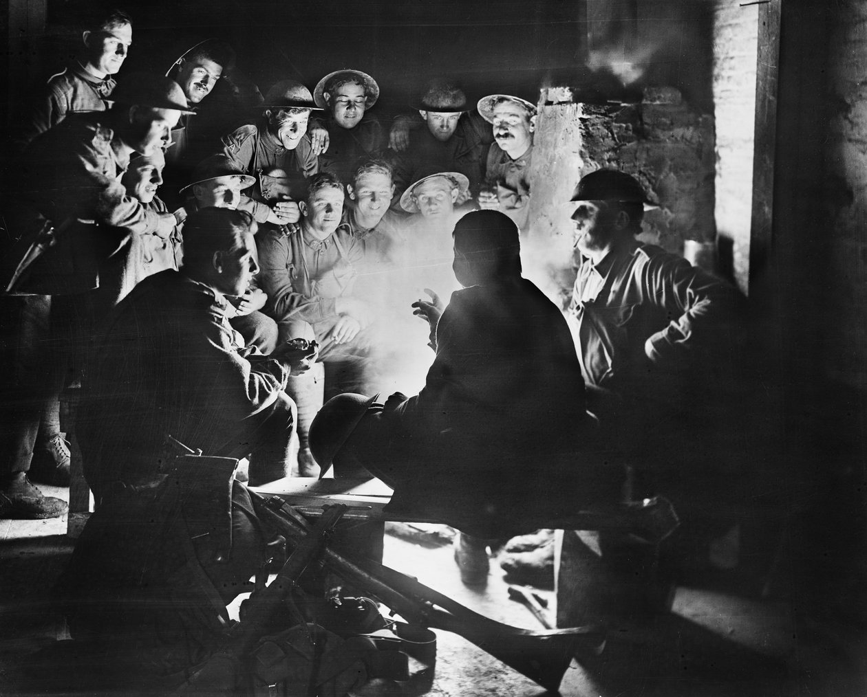 Medlemmar av 1st Australian Light Trench Mortar Battery, 1st Australian Division lyssnar på det senaste från en av sina kamrater runt en eld i ett utgravt utrymme i Ypres, 28 oktober 1917 (bw pho av Australian Photographer