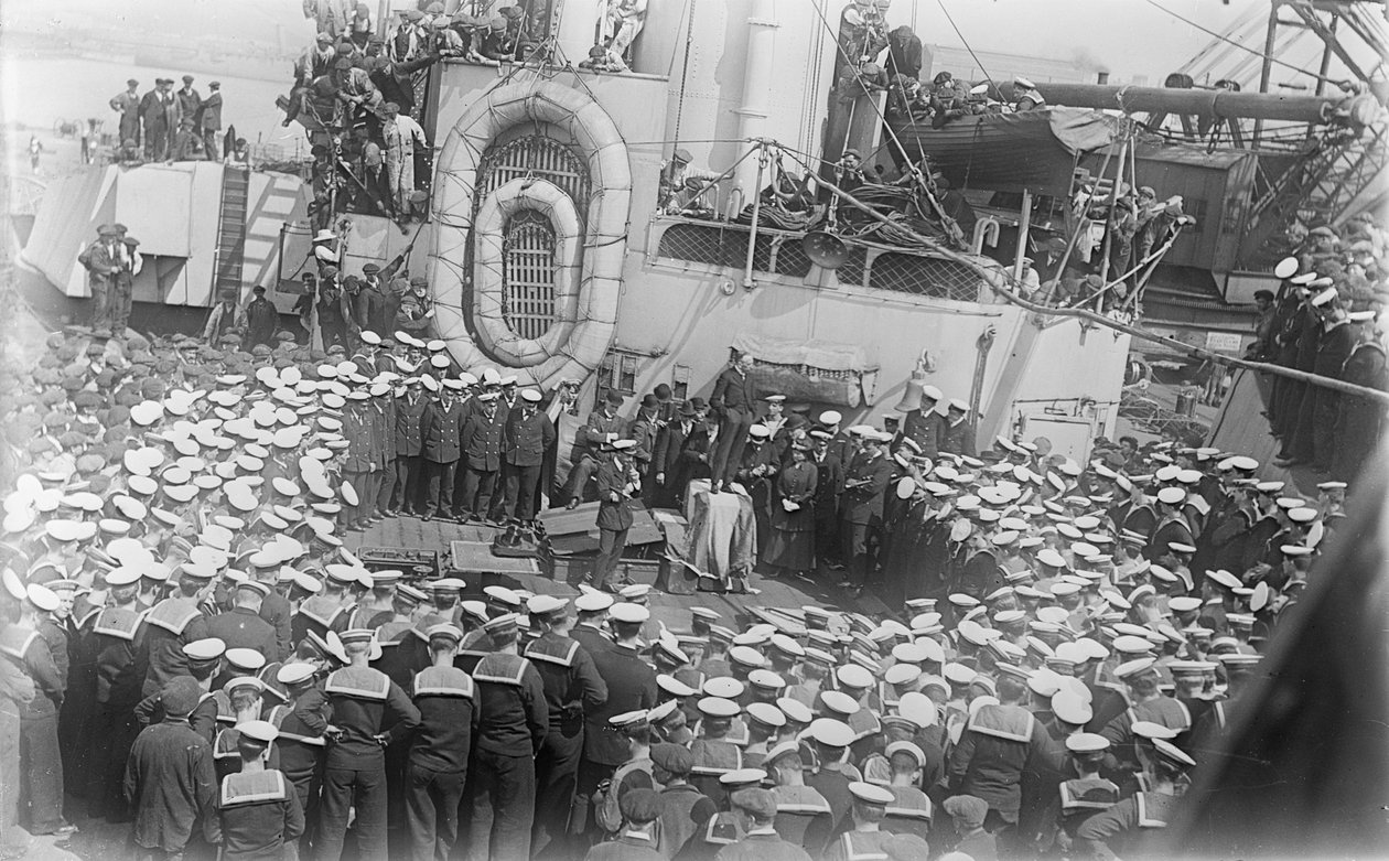 Sjömän trängs runt Australiens premiärminister The Hon William Morris (Billy) Hughes när han tilltalar dem på däcket av HMAS Australia vid varvet i Devon, England, 21 maj 1916 av Australian Photographer