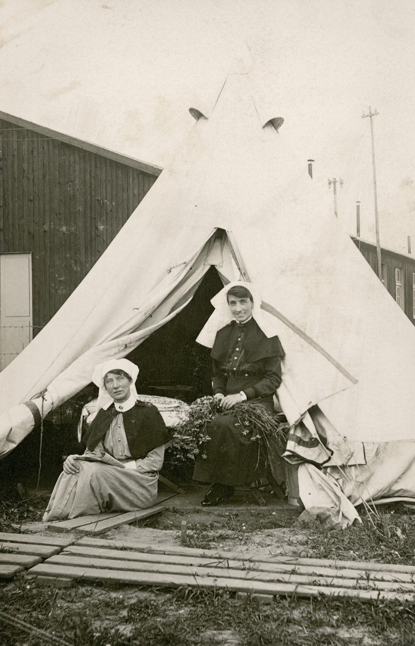 Syster Eleanor Wibmer Jeffries och syster Nellie Constance Morrice (höger) utanför sitt tält på Australian General Hospital nr 3 med blommor plockade från Sommes strand, ca. juni 1917 (bw foto av Australian Photographer