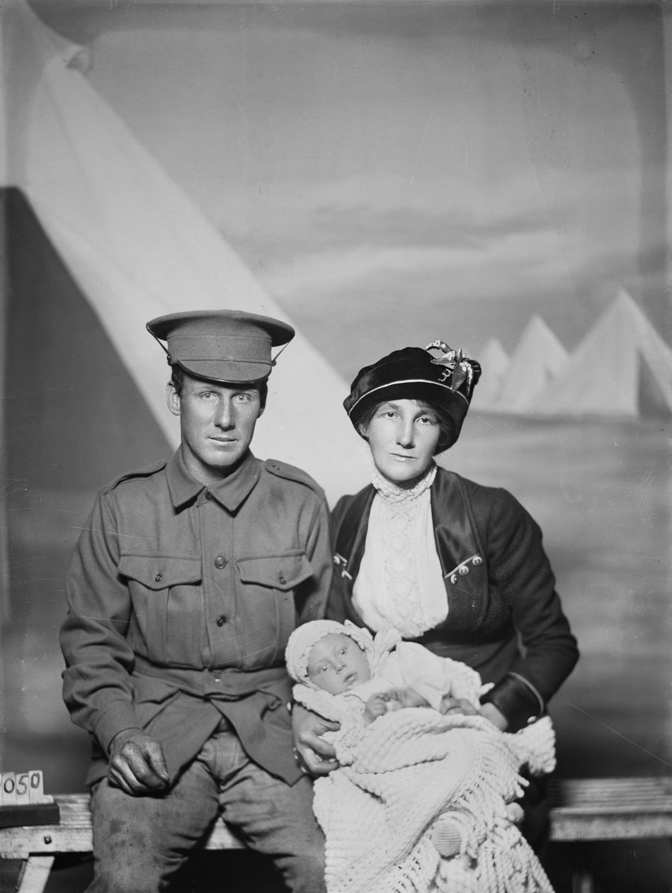 Studioporträtt av 1159 privat (Pte) George Beamish Swanton, australiensiska 24:e bataljonen, från Werribee, Victoria, med sin fru Nellie och sin lilla baby, Joan Helen, ca. maj 1915 av Australian Photographer
