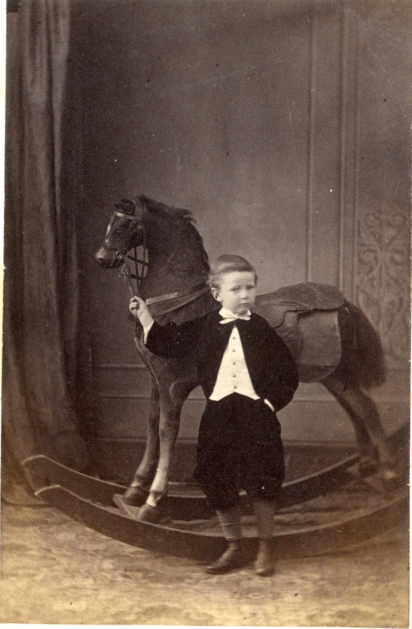 Pojke som står och håller i tyglarna på en gunghäst, 1860-talet (albuminutskrift) av Barat