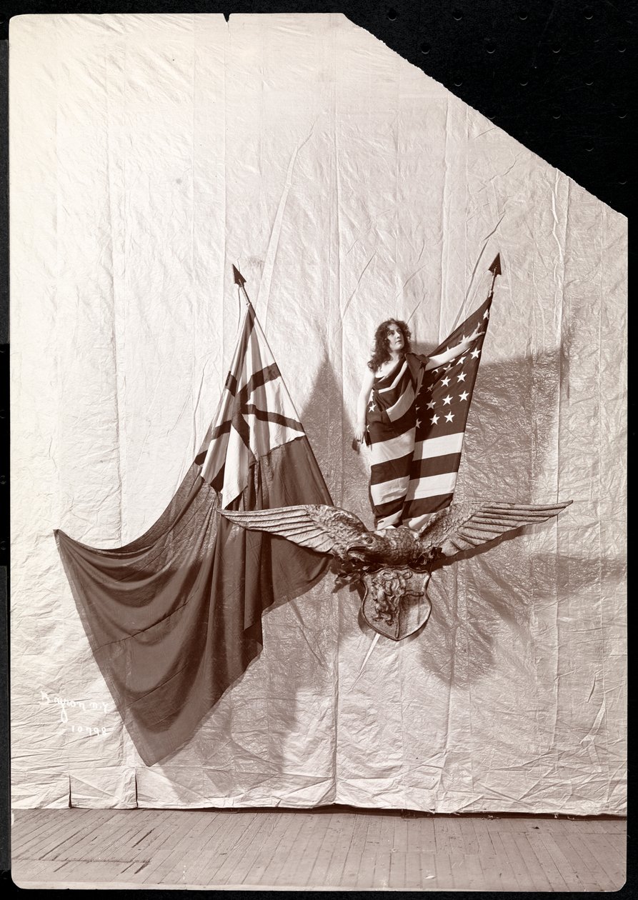 En levande bild: en modell med den amerikanska flaggan på en skulptur av en havsörn, 1900 eller 1901 (silvergelatintryck) av Byron Company