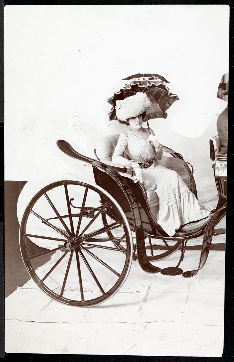 En fotomodell som sitter i en vagn och håller ett parasoll, 1902 (silvergelatintryck) av Byron Company