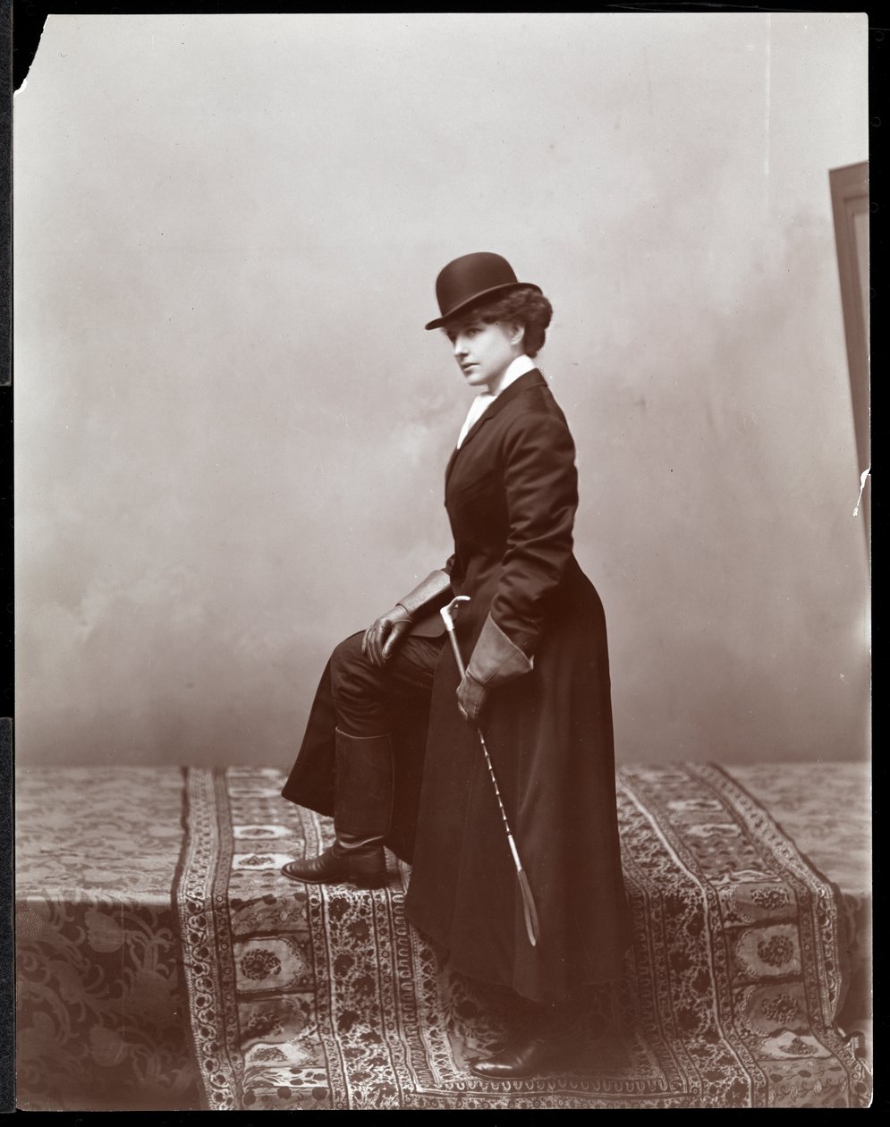 En kvinnlig modell poserar i illustratören Malcolm Strauss studio, ca 1895 (silvergelatintryck) av Byron Company