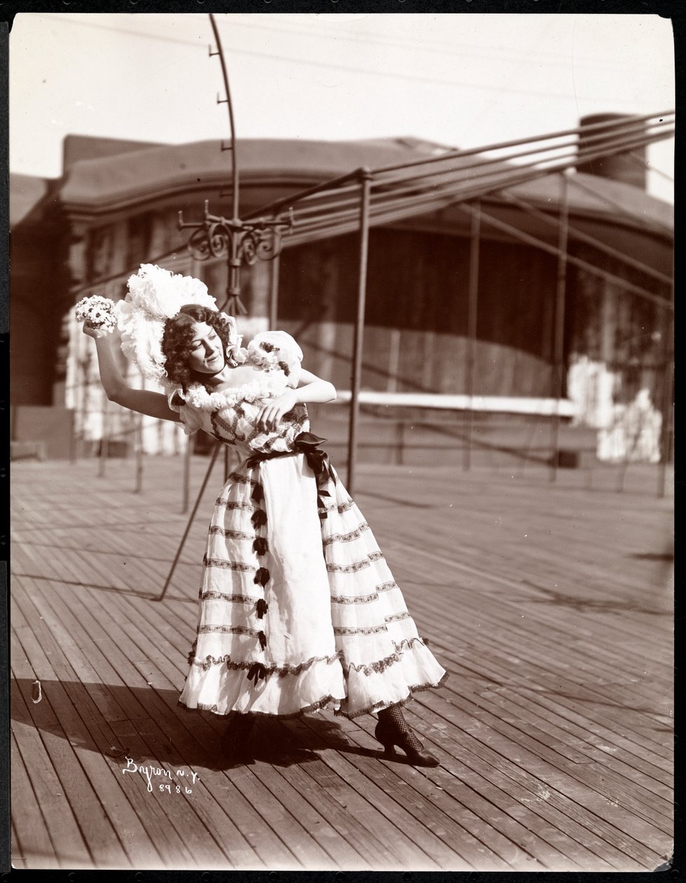 En skådespelerska i kostym repeterar på taket till vad som troligen är New York Theatre, New York, 1900 (silvergelatintryck). av Byron Company