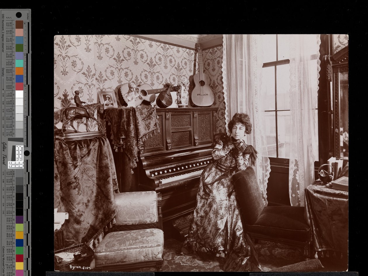 Anita Chartres sitter vid en pianospelare, ca 1898 (silvergelatintryck) av Byron Company