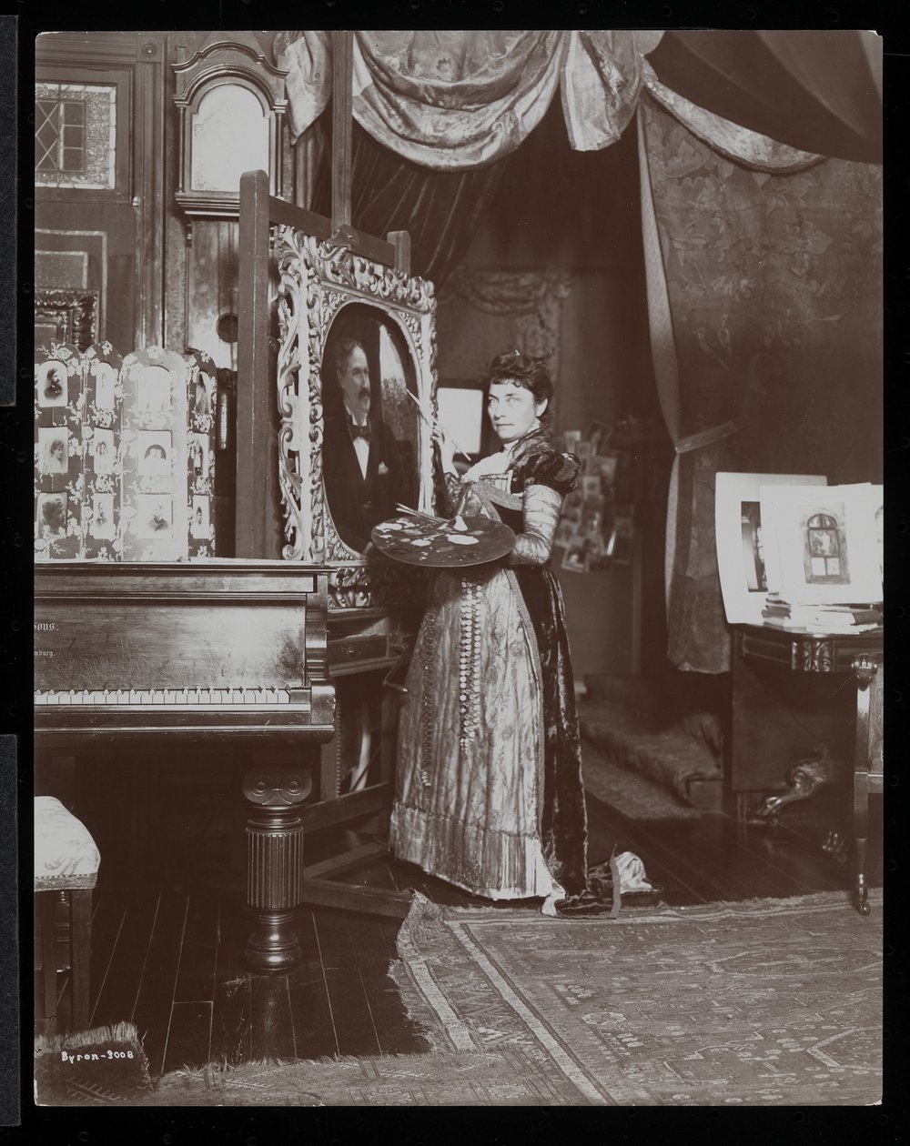 Konstnären Mary Tillinghast målar ett porträtt i sin studio, New York, ca 1897 (silvergelatintryck) av Byron Company