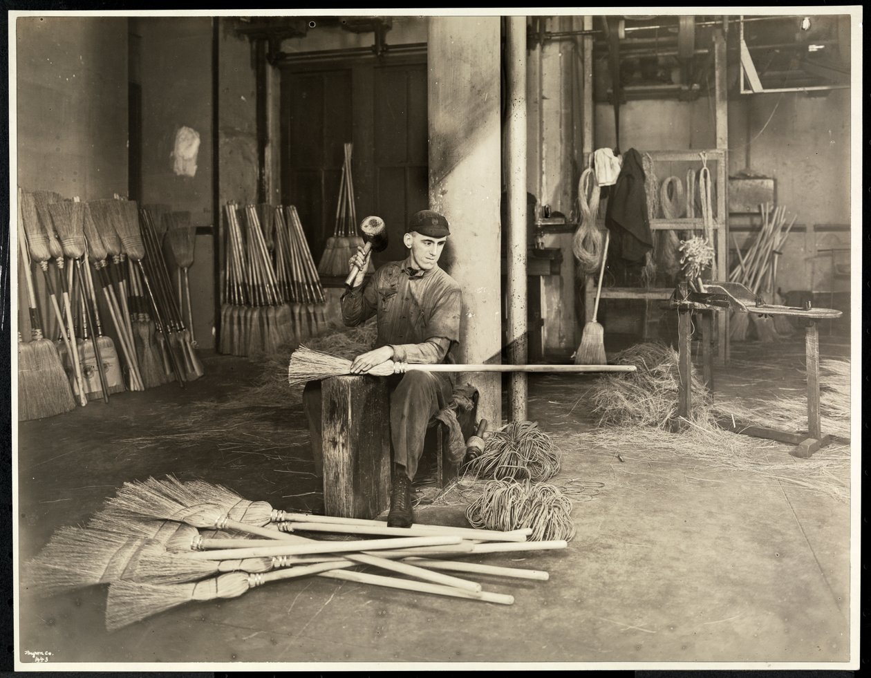 Blind man placerar järnband på kvastar i Bourne Memorial Building, New York, 1921 (silvergelatinprint) av Byron Company