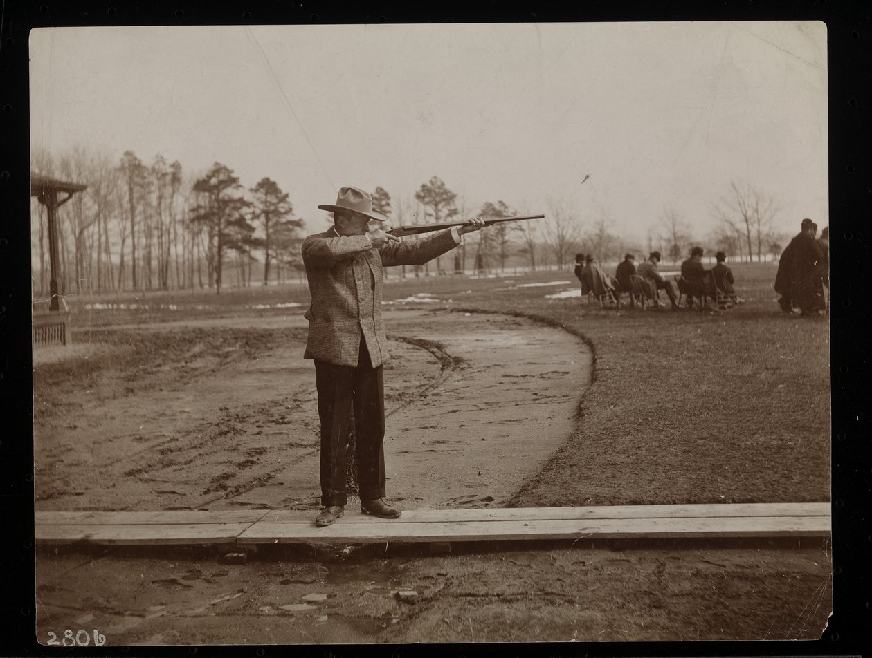 Frank Work siktar på ett gevär vid en trapskytte, New York, 1896 (silvergelatintryck) av Byron Company