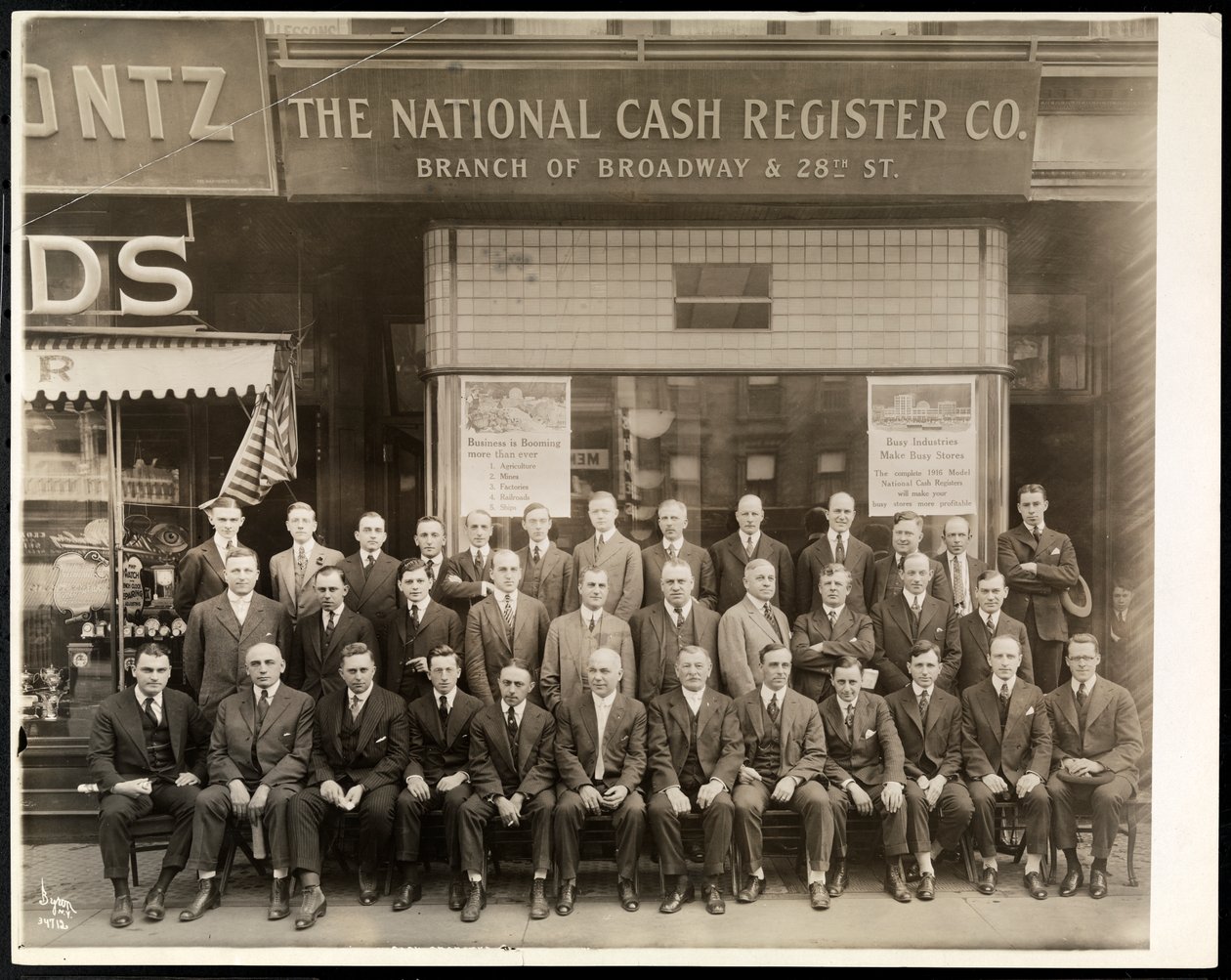 Grupp män från National Cash Register Co. poserade framför Broadway and 28th Street filial, New York, 1916 (silvergelatintryck) av Byron Company