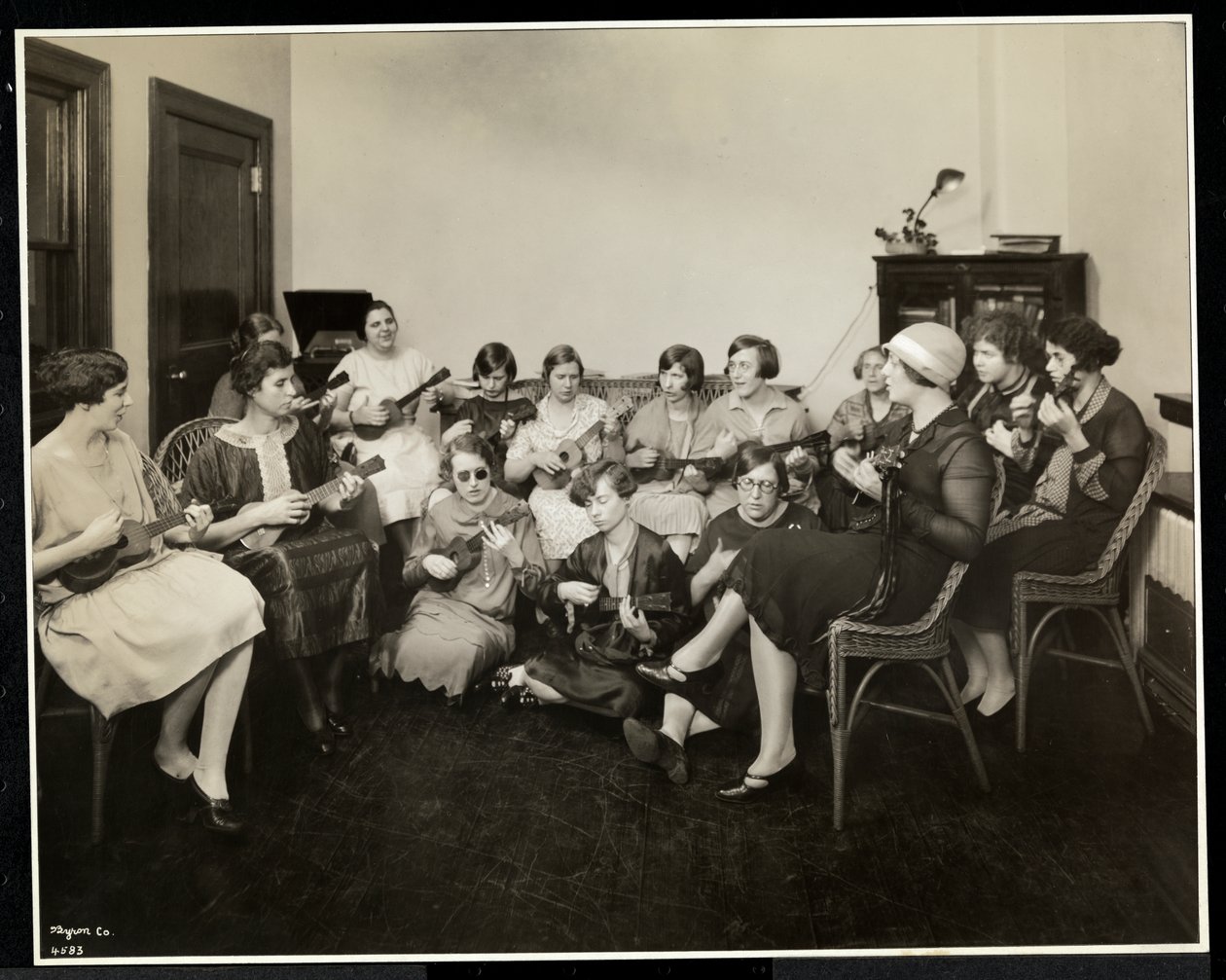 Grupp unga blinda kvinnor som spelar ukeleles på New York Association for the Blind, 111 East 59th Street, New York, 1926 (silvergelatintryck) av Byron Company