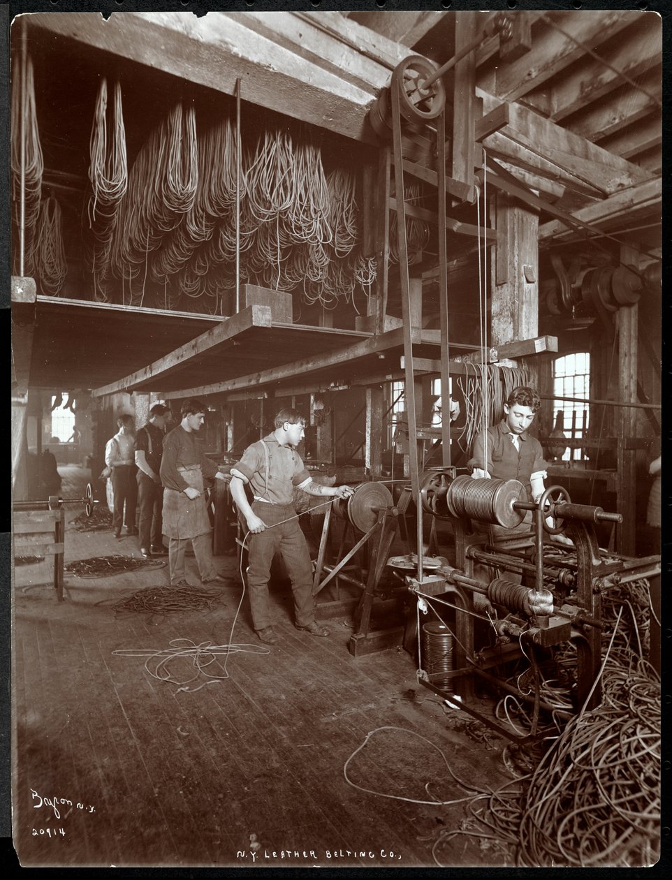 Interiörvy av en man som arbetar med läder på New York Leather Belting Co., New York, 1906 (silvergelatintryck) av Byron Company
