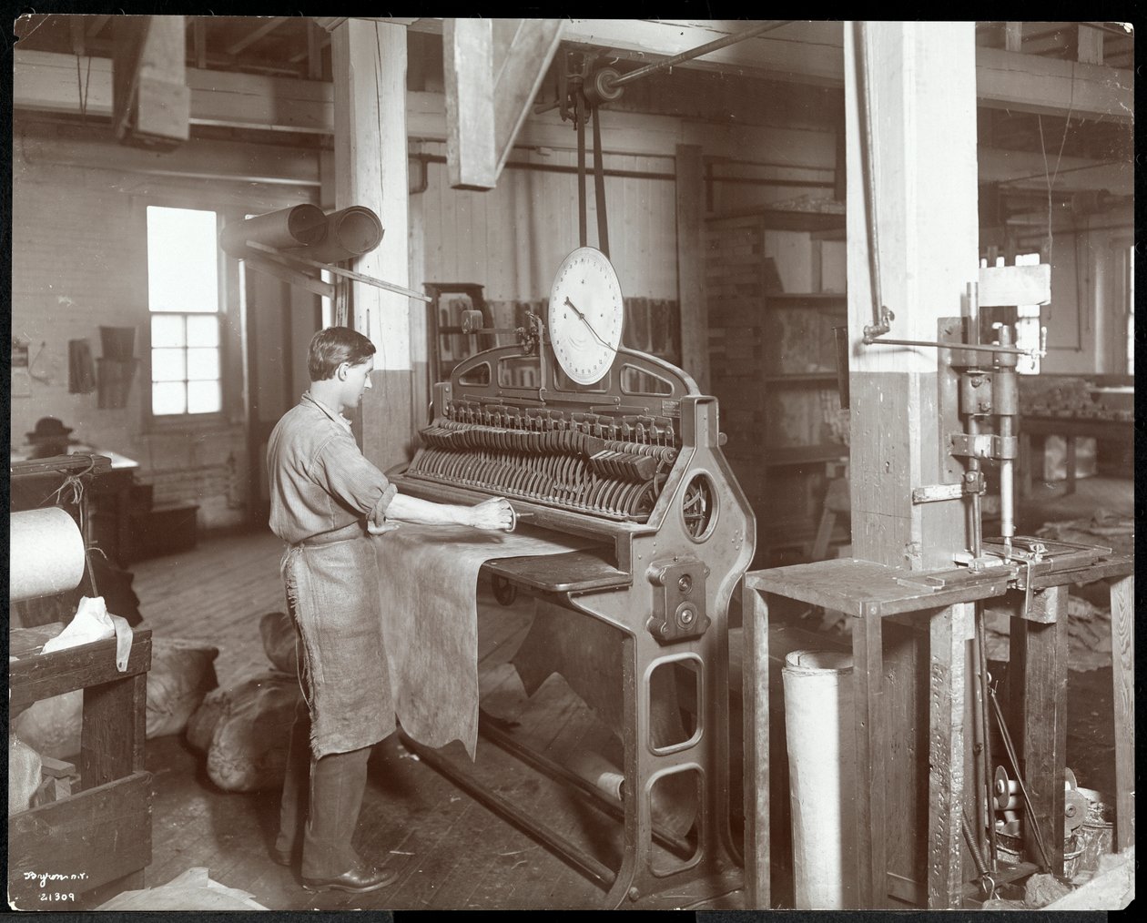 Interiörvy av en man som arbetar med läder på New York Leather Belting Co., New York, 1906 (silvergelatintryck) av Byron Company