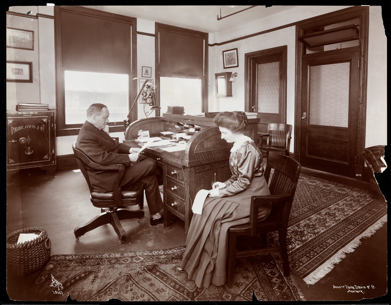 Man med sin sekreterare tar diktering på ett privat kontor i Parke, Davis und Co., kemister, Hudson und Vestry Streets, New York, 1910 (silvergelatintryck) av Byron Company