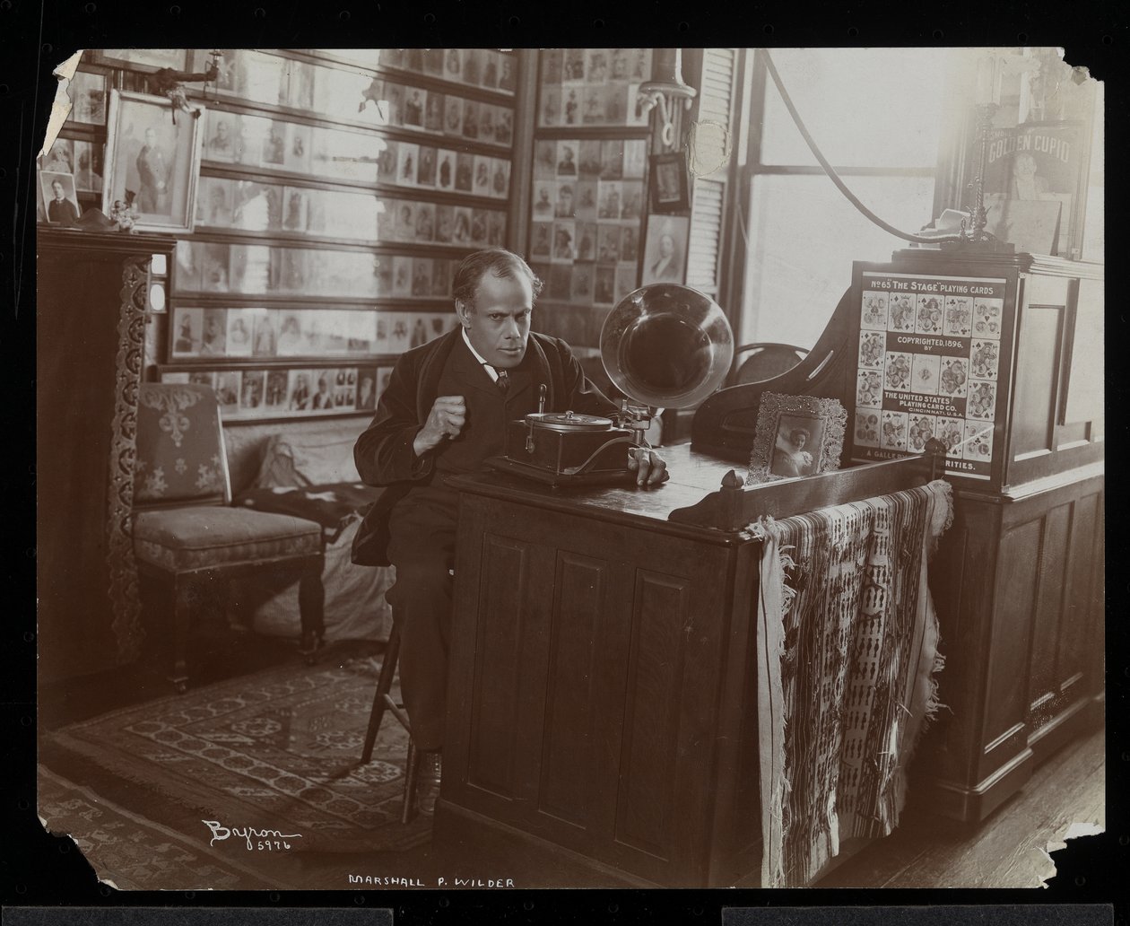 Marshall P. Wilder lyssnar på en skiva på en victrola på sitt kontor, 1898-99 (silvergelatintryck) av Byron Company