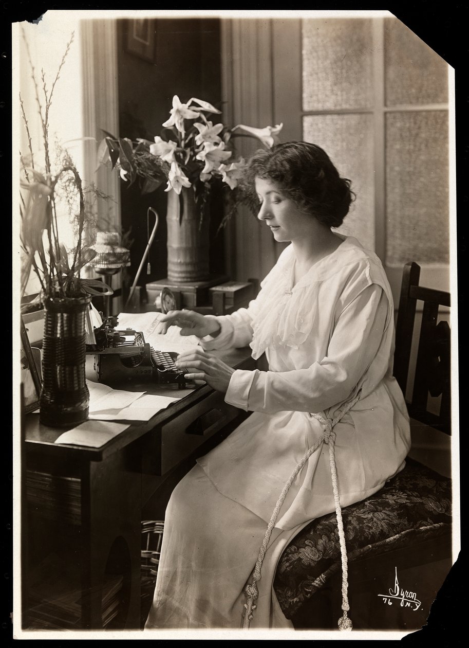 Maude Fealy sittande vid en skrivmaskin, ca 1915 (silvergelatintryck) av Byron Company