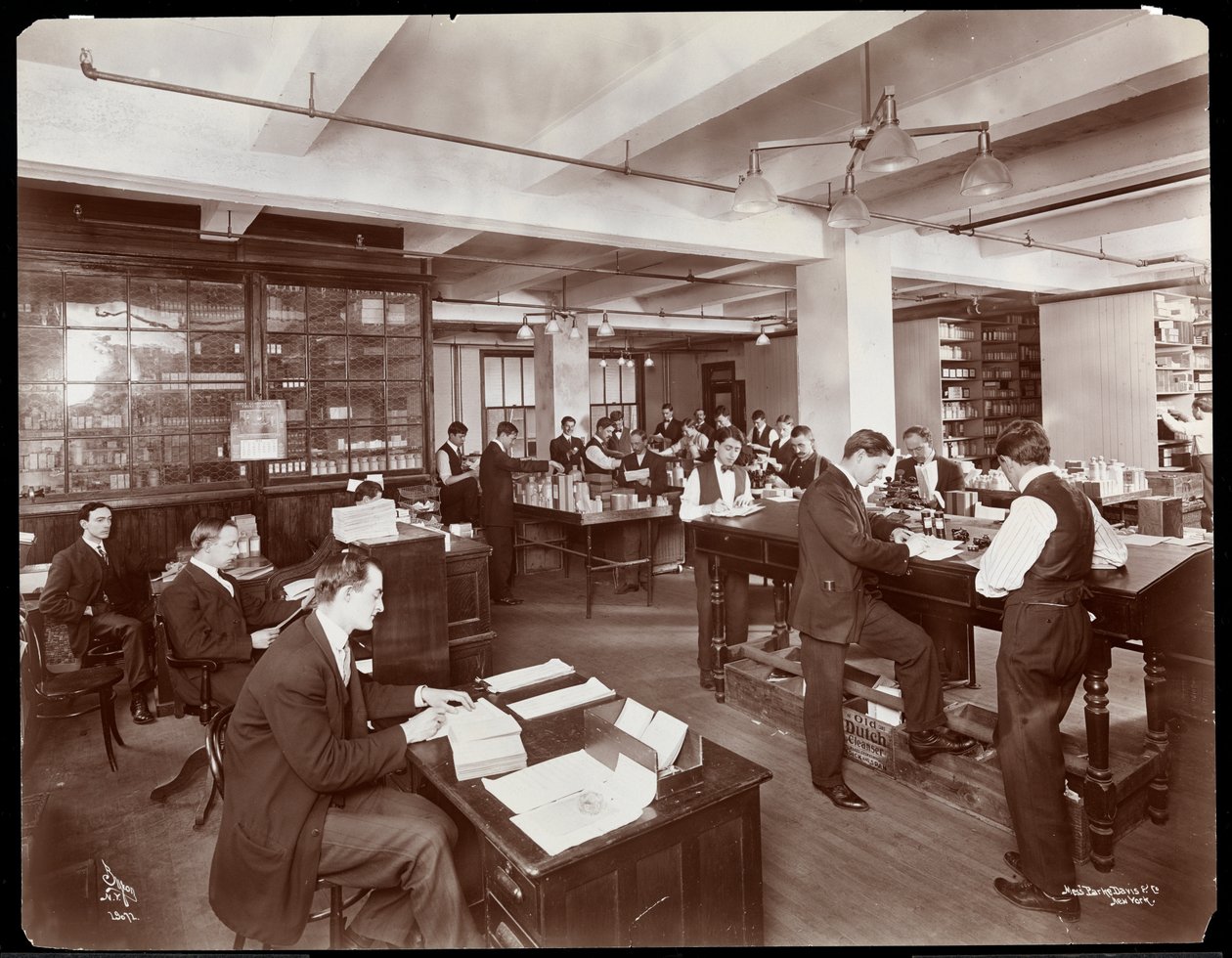 Män som fyller i beställningar på ett kontor hos kemisterna Parke, Davis och Co. på Hudson och Vestry Streets i New York, 1910 (silvergelatintryck). av Byron Company