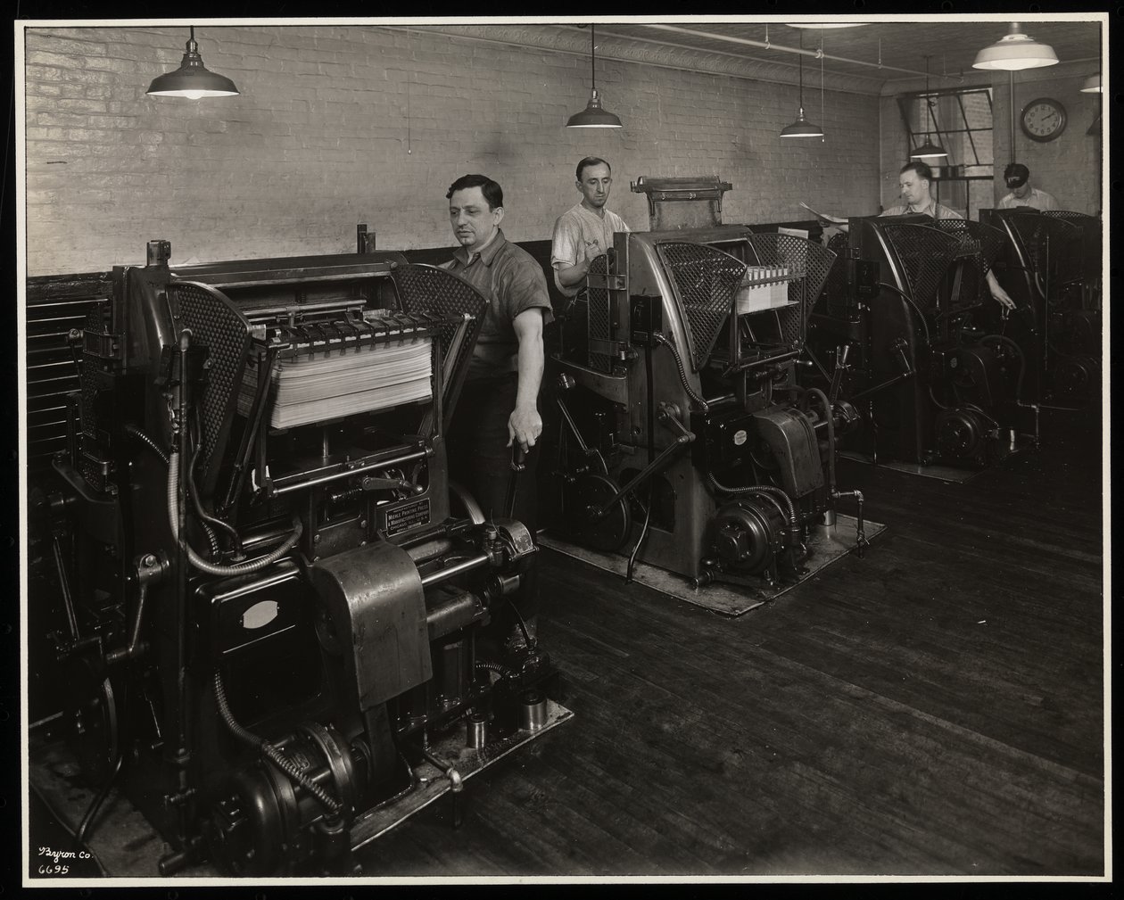 Män som arbetar med tryckpressar på Unz und Co., 24 Beaver Street, New York, 1932 (silvergelatintryck) av Byron Company