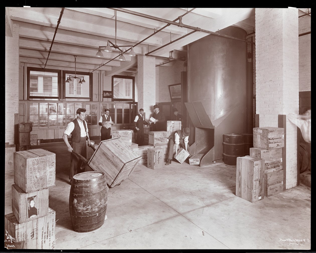 Män som arbetar med lådor i expeditionsavdelningen hos kemisterna Parke, Davis und Co. på Hudson och Vestry Street i New York 1910 (silvergelatin). av Byron Company