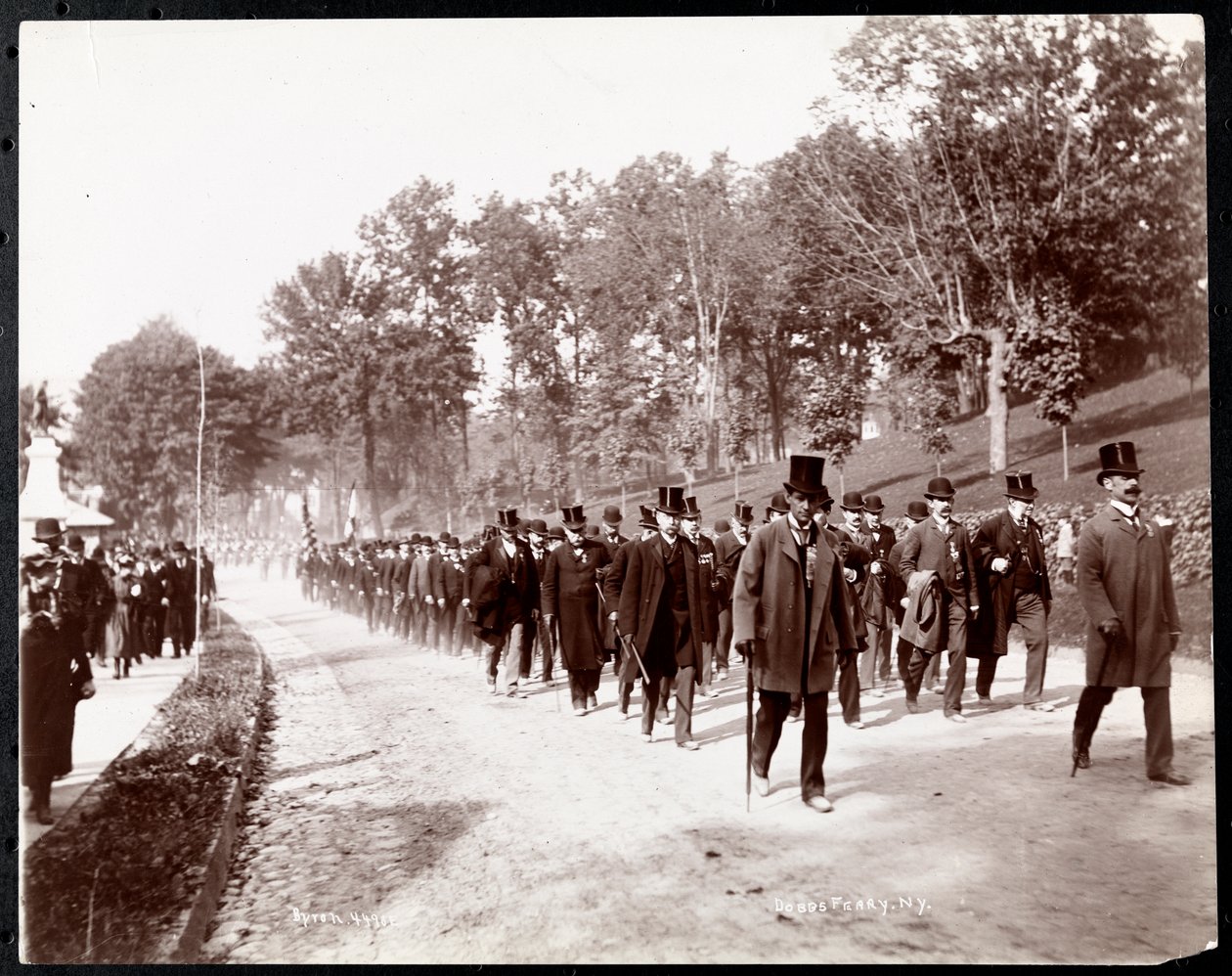 Militärparad med uniformerade män i höga hattar i Dobbs Ferry, New York, 1898 (silvergelatintryck) av Byron Company
