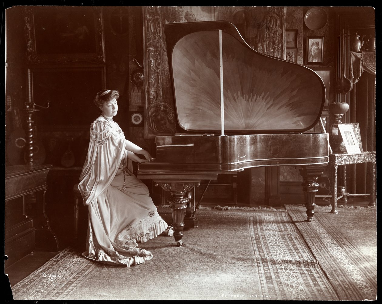 Mrs. I. M. Clark sittande vid en flygel, 1904 (silvergelatintryck) av Byron Company