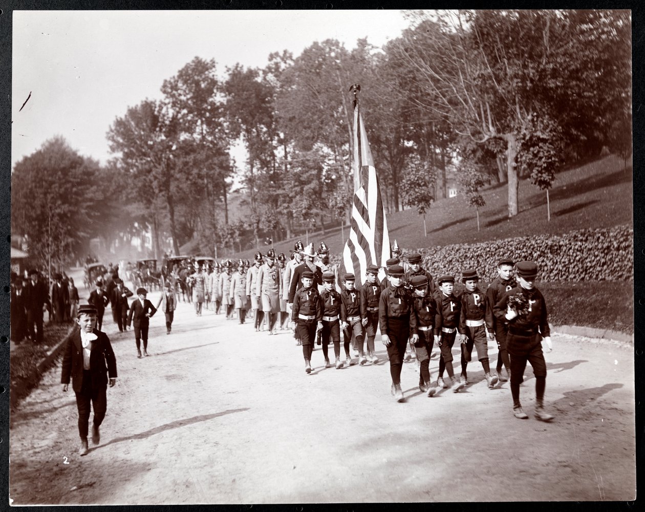 Parad med barn och brandmän som marscherar i Dobbs Ferry, New York, 1898 (silvergelatintryck) av Byron Company