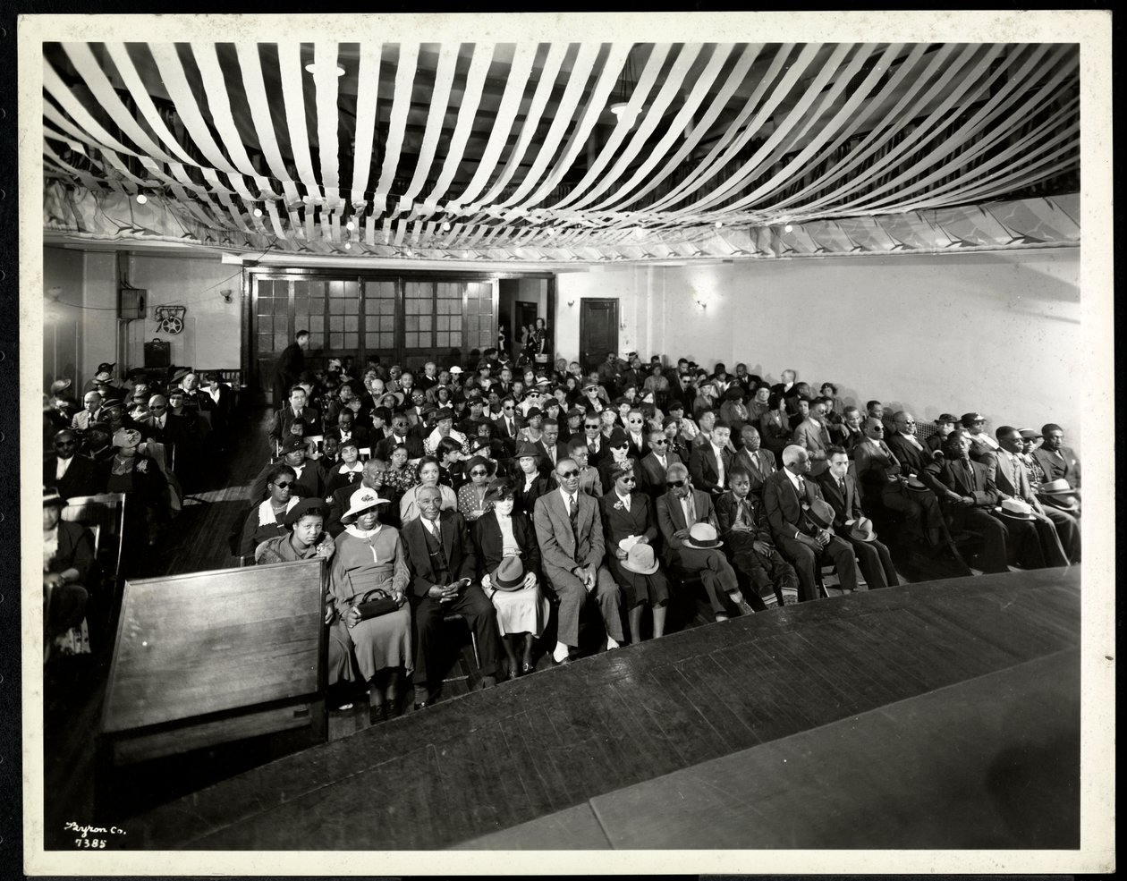 Taget från scenen för en publik vid en färgad fest i auditoriet i New York Association for the Blind, 111 New York East 59th Street, New York, 1937 (silvergelatintryck) av Byron Company