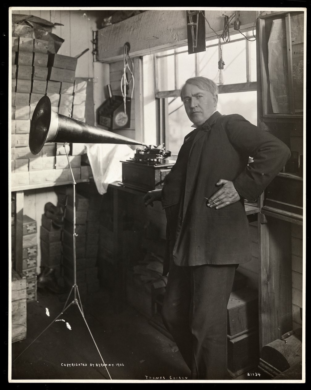 Thomas Edison står bredvid en fonograf i sitt laboratorium, 1920 (silvergelatintryck) av Byron Company