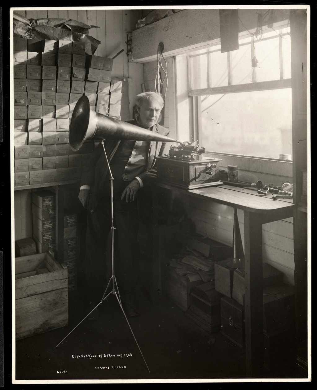 Thomas Edison står bredvid en fonograf i sitt laboratorium, 1920 (silvergelatintryck) av Byron Company