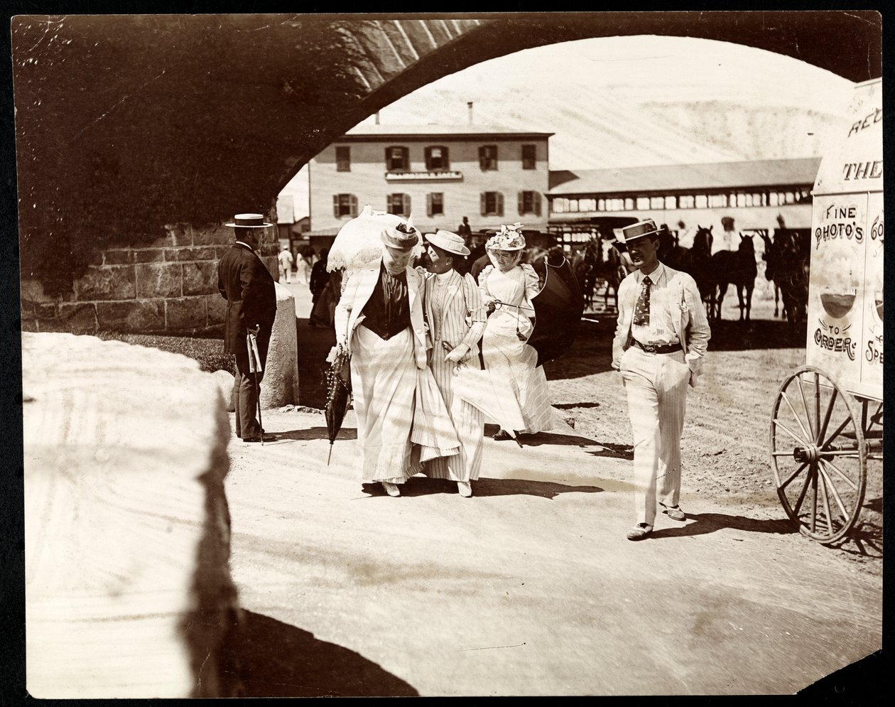 Tre kvinnor och en man som går vid Narragansett Pier med ambulerande fotografs vagn, Rhode Island, 1891 (silvergelatintryck) av Byron Company