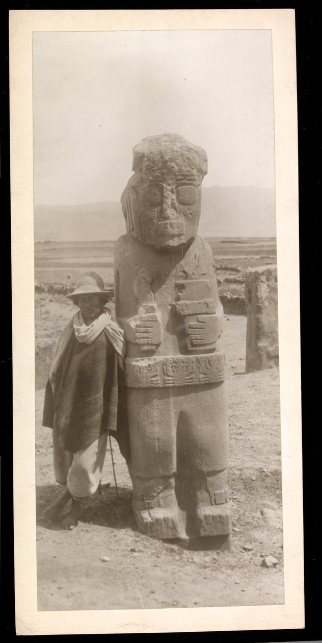 Vy över en stor skulpterad figur, tydligen en antikvitet, med en man stående bredvid, 1896 (silvergelatintryck) av Byron Company