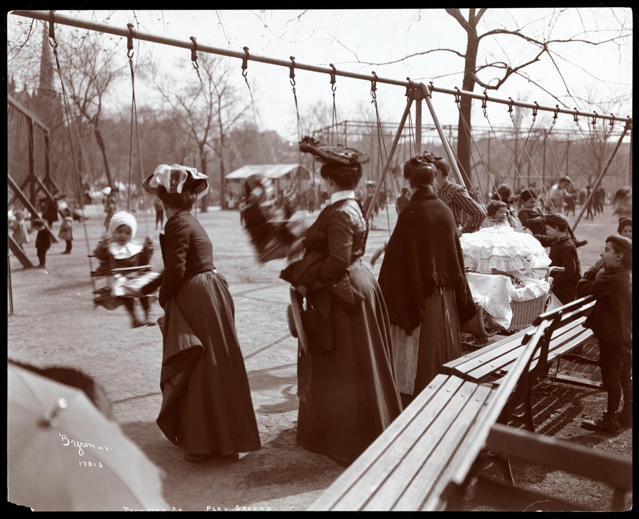 Vy över en kvinna som knuffar barn på gungorna i Tompkins Square Park, på Arbor Day, New York, 1904 (silvergelatintryck) av Byron Company