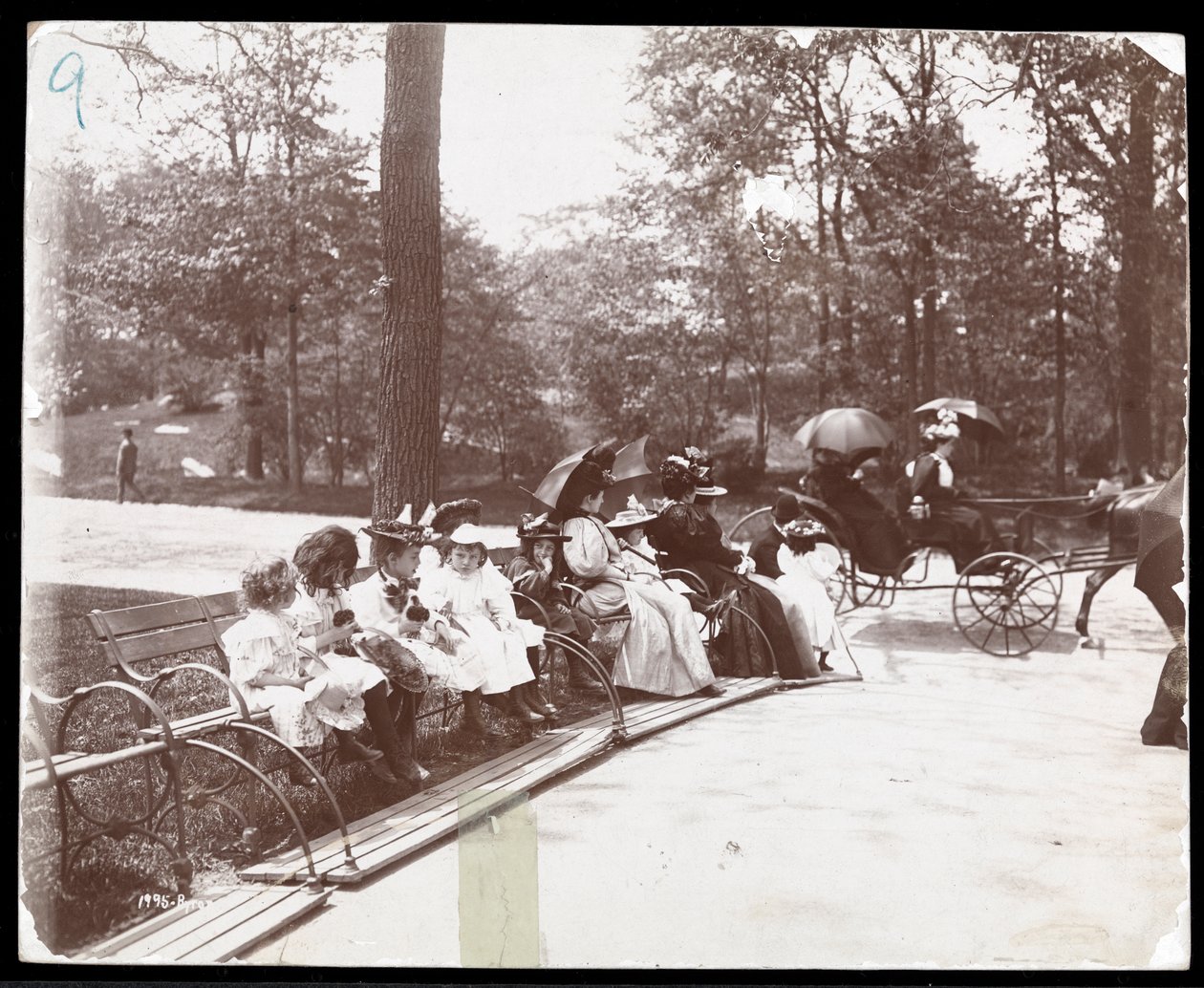Vy över kvinnor och barn sittande på bänkar i Central Park, New York, 1898 (silvergelatintryck) av Byron Company