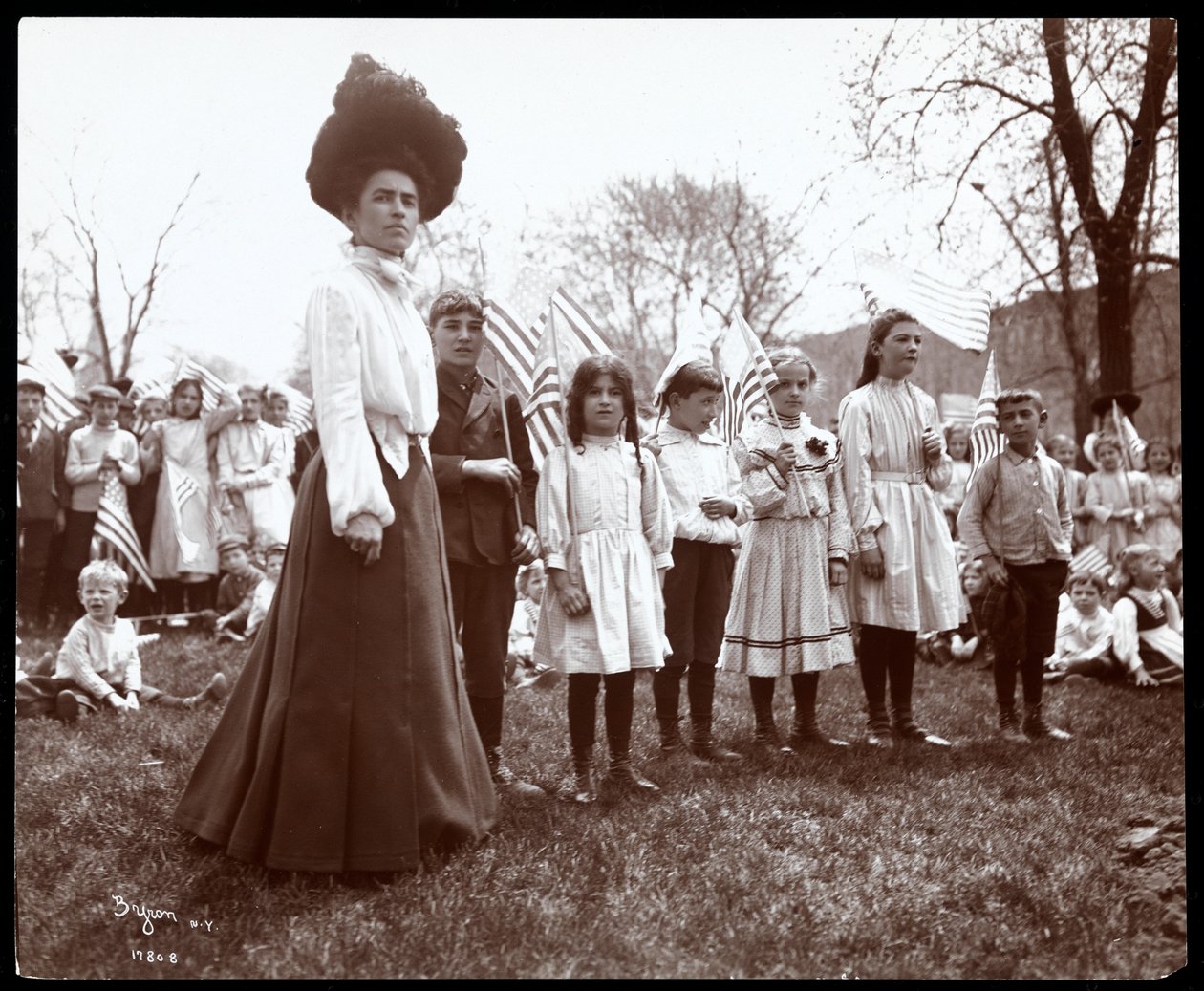 Kvinna med barn som håller flaggor på Arbor Day i Tompkins Square Park, New York, 1904 (silvergelatintryck) av Byron Company